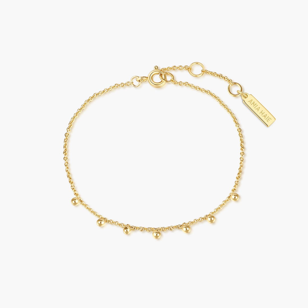 Niche Jewellery Ania Haie gold chain bracelet featuring delicate dangling beads at intervals on a spring ring clasp.