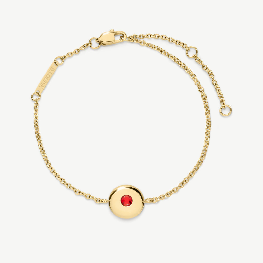 Niche Jewellery gold chain bracelet with a round red July birthstone charm. Adjustable clasp, waterproof stainless steel.
