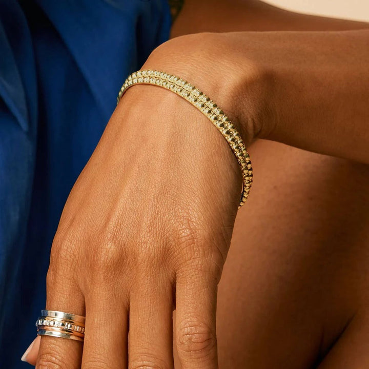 Niche Jewellery Charlotte's Web gold vermeil Maharani stacking bangle with delicate bubble texture worn on a woman's wrist.
