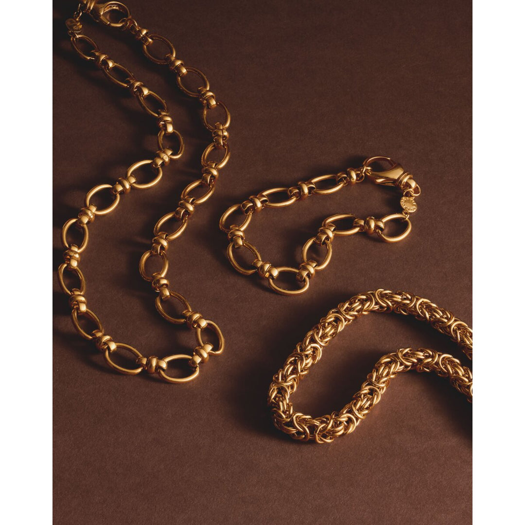 Niche Jewellery Katie Loxton Empire waterproof gold-tone chain bracelet with chunky links on a brown background