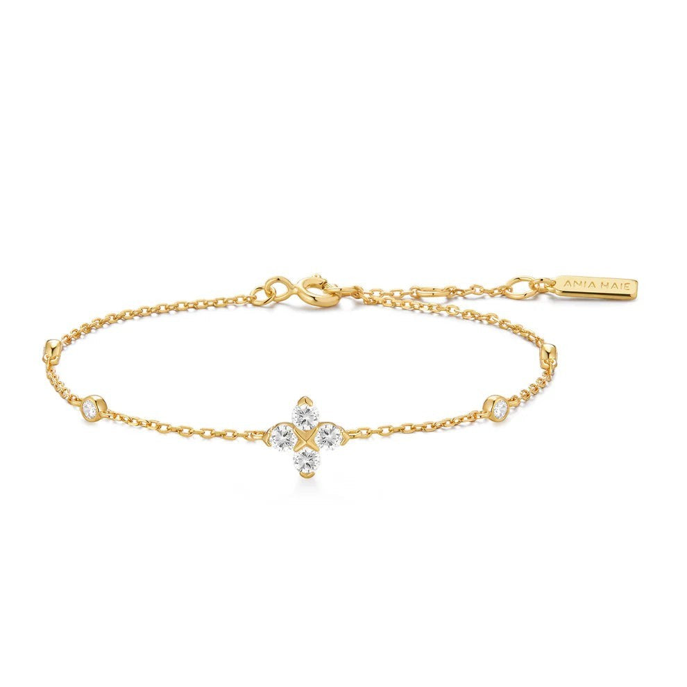 Niche Jewellery Ania Haie gold chain bracelet featuring a sparkling four-leaf clover charm with clear cubic zirconia
