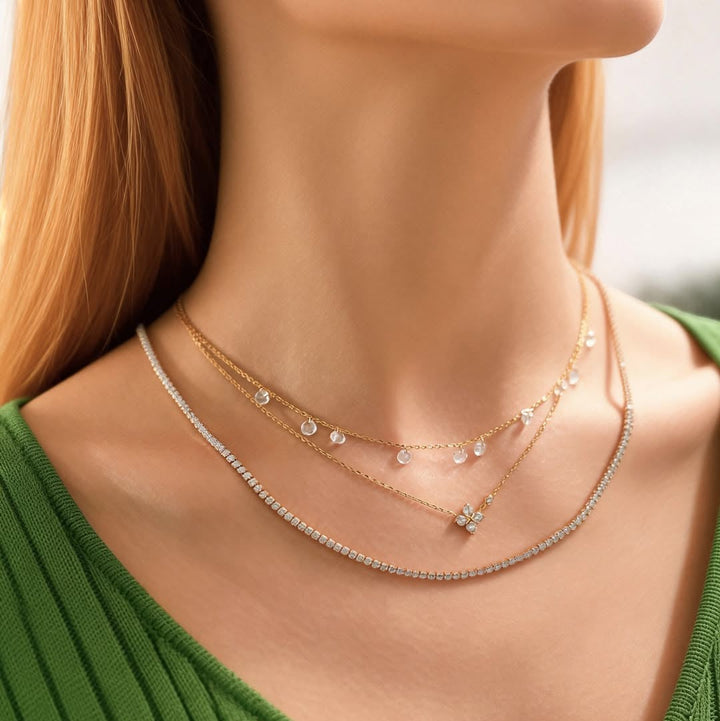 Niche Jewellery Ania Haie gold clover necklace with cubic zirconia layered with delicate chains on a model