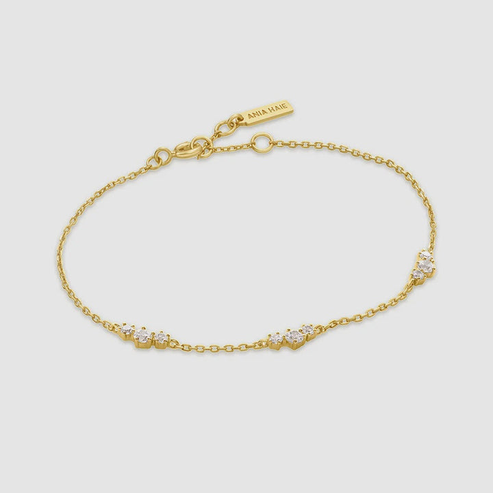 Niche Jewellery Ania Haie gold-plated chain bracelet featuring scattered cubic zirconia cluster stations.