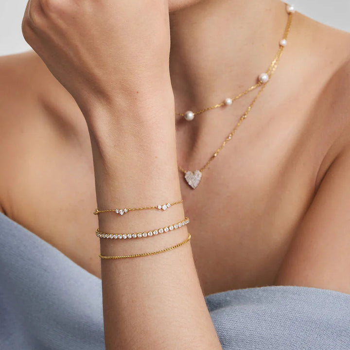 Niche Jewellery Ania Haie gold-plated cluster station bracelet with cubic zirconia stones worn on a woman's wrist