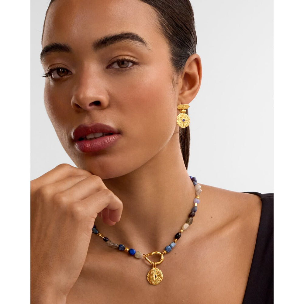 Niche Jewellery Katie Loxton gold earrings with dark lapis lazuli stones worn by a model with a matching necklace.