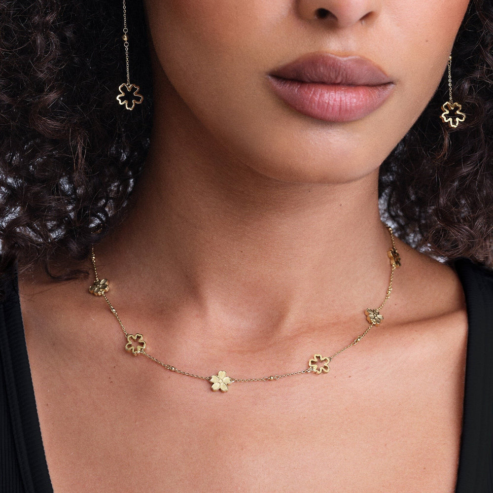 Niche Jewellery Olivia Burton gold-plated forget-me-not floral necklace worn on a model with matching drop earrings