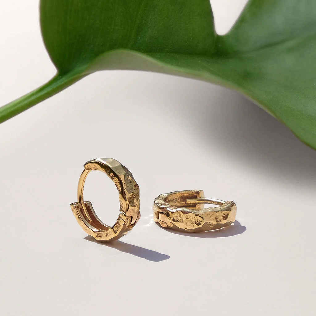 Niche Jewellery Charlotte's Web Lakshmi gold vermeil huggie hoops with a hammered artisan texture on a white surface.