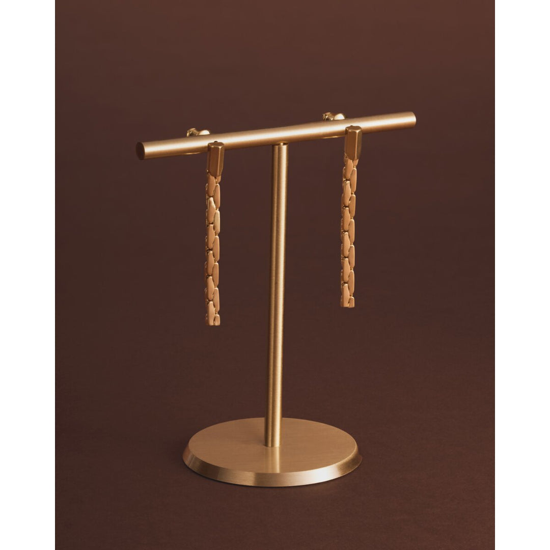 Niche Jewellery Katie Loxton gold-tone waterproof drop stud earrings with a diamond-check pattern on a display stand.
