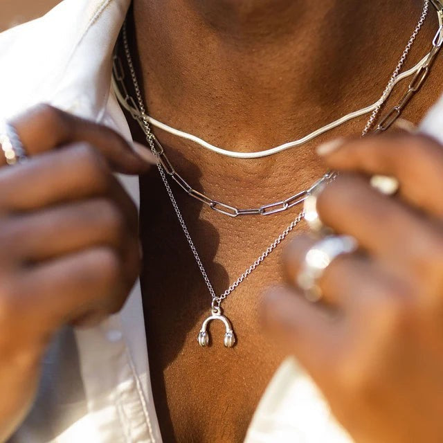 Niche Jewellery Scream Pretty gold headphones pendant necklace layered with silver chains on a model