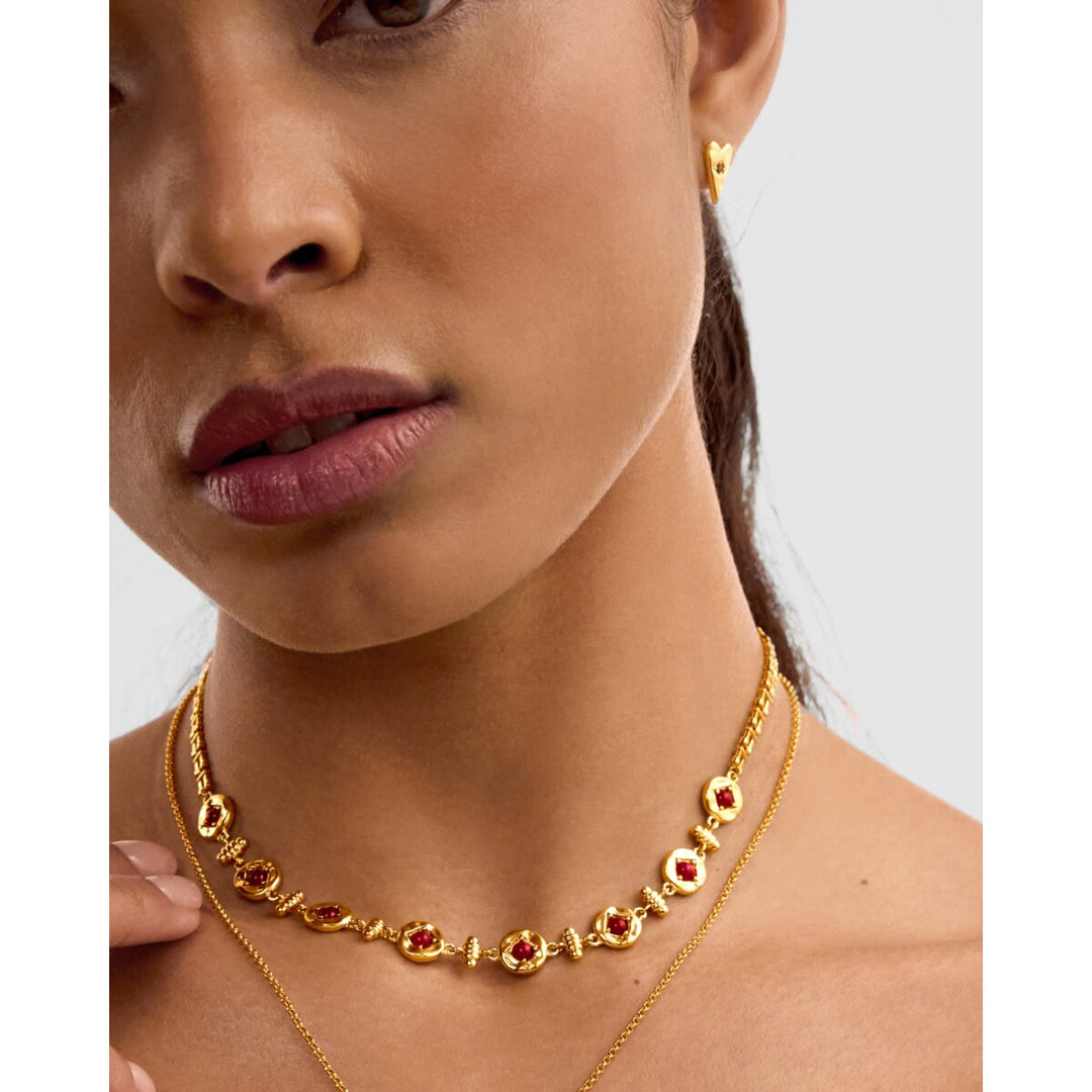 Niche Jewellery Katie Loxton waterproof gold heart earrings with deep red accents worn by a model