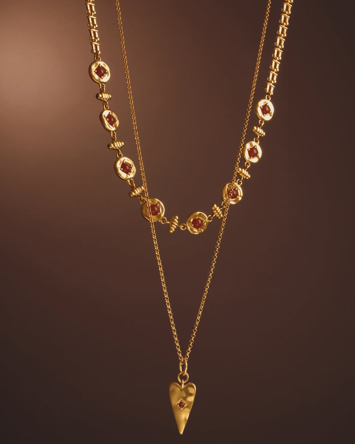 Niche Jewellery Katie Loxton gold-tone layered necklace featuring a red heart pendant and decorative red stone links.