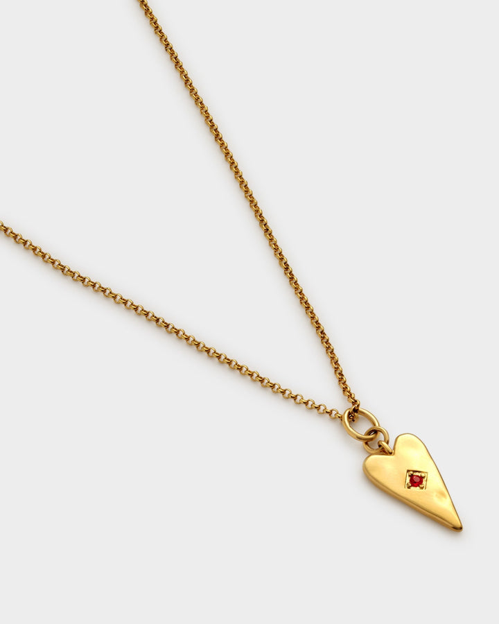 Niche Jewellery Katie Loxton gold-tone necklace featuring a sleek heart pendant with a small red stone accent.