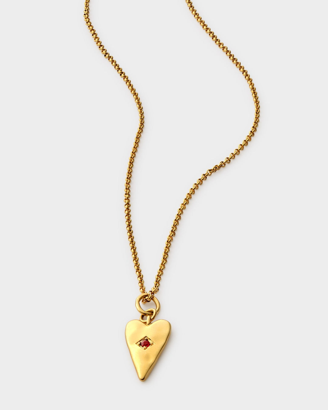 Niche Jewellery Katie Loxton gold heart necklace with a small red stone on a delicate gold-tone chain.