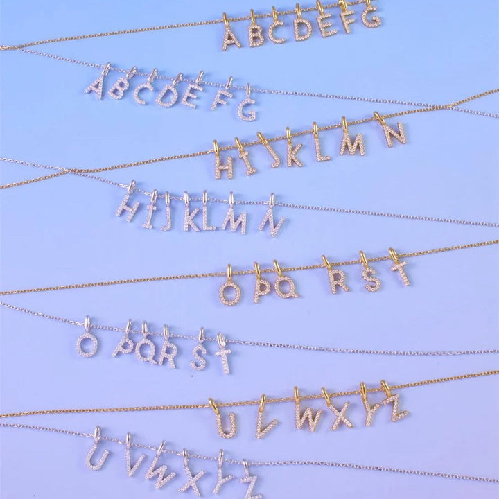 Niche Jewellery Ania Haie gold-plated initial necklaces featuring sparkling pavé letter pendants on fine chains.