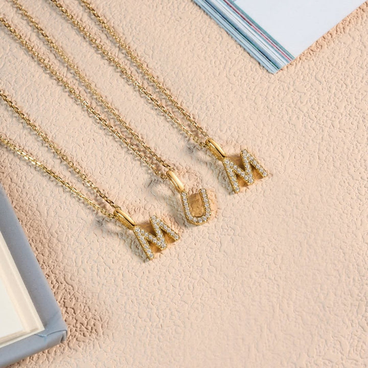 Niche Jewellery Ania Haie gold initial necklaces spelling MUM with pavé crystal accents on delicate chains