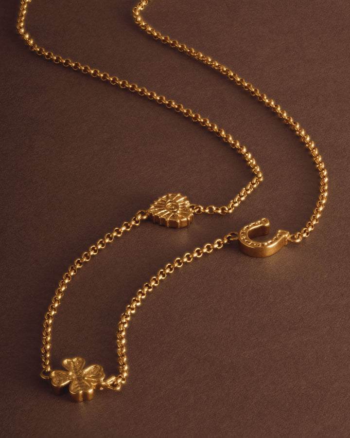 Niche Jewellery Katie Loxton gold-tone waterproof necklace featuring lucky charm symbols on a delicate chain.