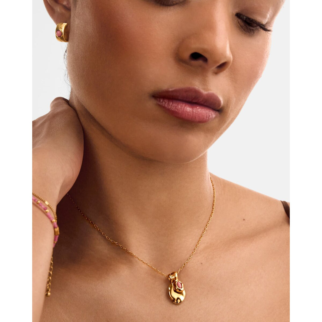 Niche Jewellery Katie Loxton waterproof gold necklace with a pink October birthstone worn by a model.