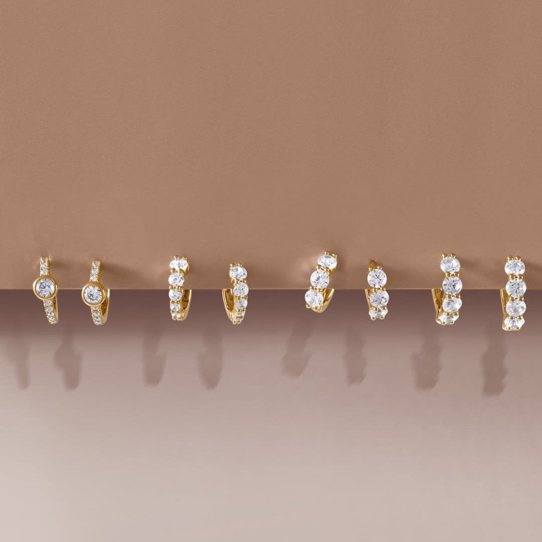 Niche Jewellery Ania Haie gold huggie hoop earrings featuring pavé cubic zirconia and bezel-set stones.