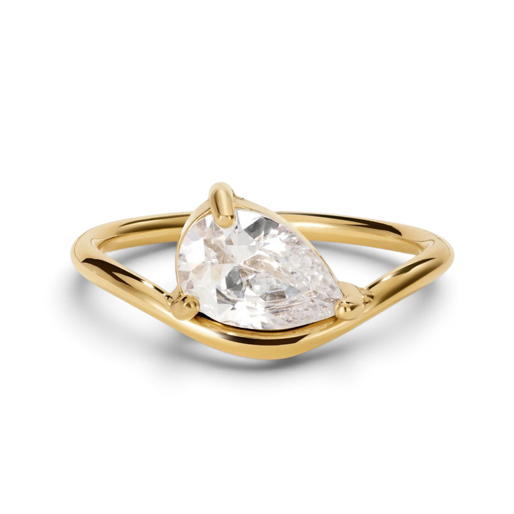 Niche Jewellery D.Louise gold promise ring featuring a clear pear-shaped stone in a modern teardrop setting.