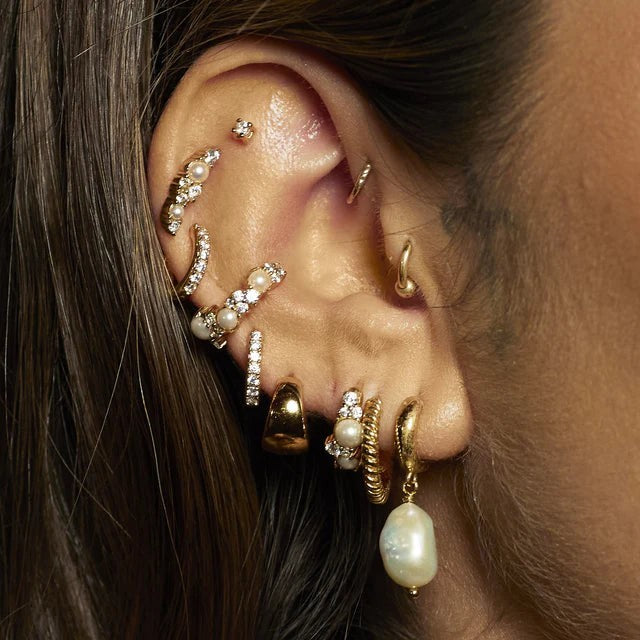 Niche Jewellery Scream Pretty Hannah Martin gold pearl ear cuff worn in a curated ear stack with multiple piercings.