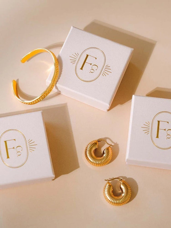 Niche Jewellery Formation Co Lila gold plated sculptural hoop earrings and matching cuff with branded gift boxes