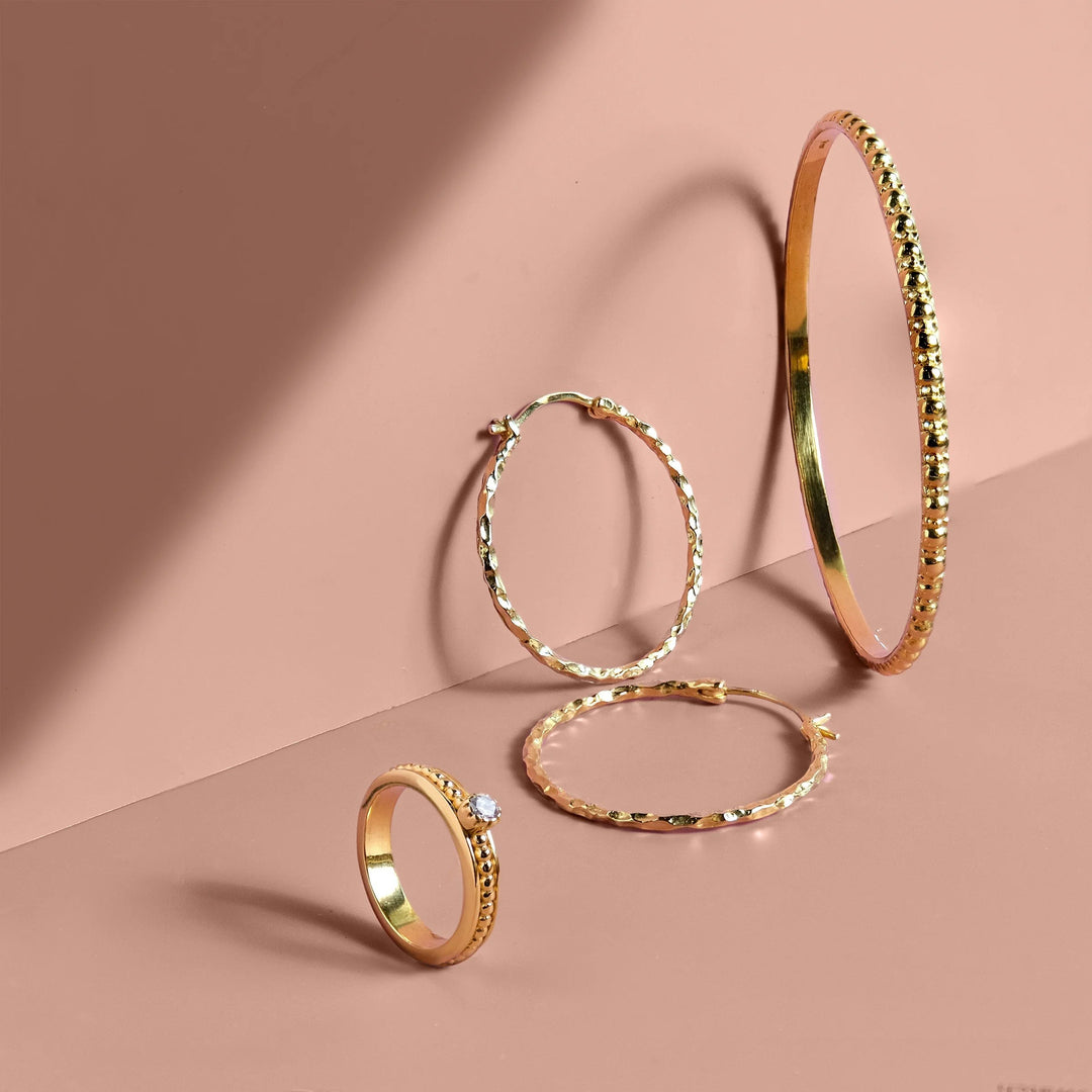 Niche Jewellery Charlotte's Web gold vermeil stacking bangle with bubble texture, hoop earrings, and a solitaire ring.