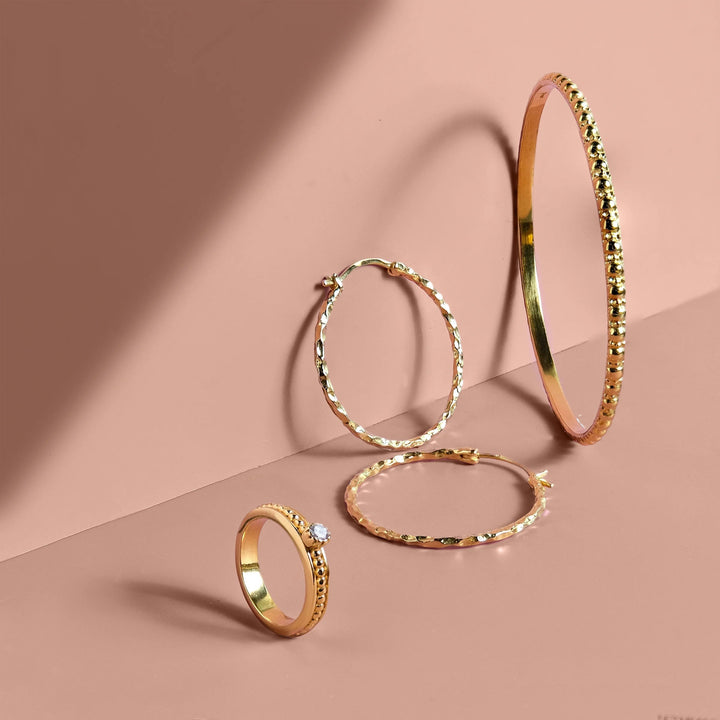 Niche Jewellery Charlotte's Web gold vermeil stacking bangle with bubble texture, hoop earrings, and a solitaire ring.
