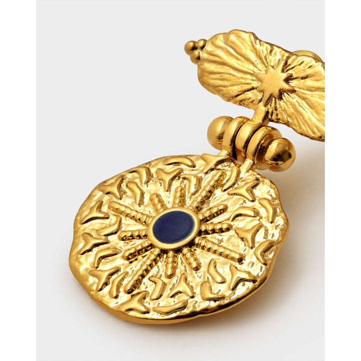 Niche Jewellery Katie Loxton gold-tone waterproof earrings featuring a textured sunburst design and dark lapis stone.