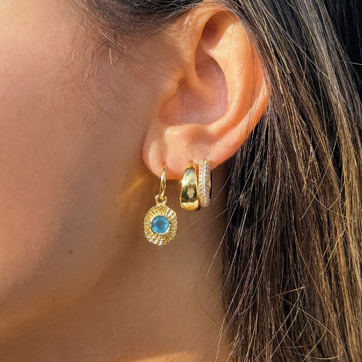 Niche Jewellery Sarah Alexander gold drop earring with blue gemstone talisman charm worn in a layered ear stack