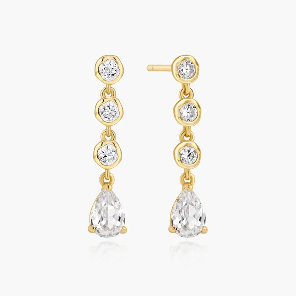 Niche Jewellery Ania Haie gold stud earrings featuring a molten design with bezel-set round and teardrop crystals.