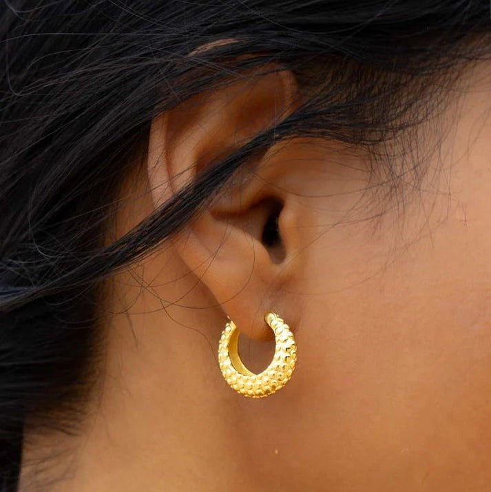 Niche Jewellery Formation Co Shore oval hoop earrings in 18k gold plated sterling silver with textured rock finish.