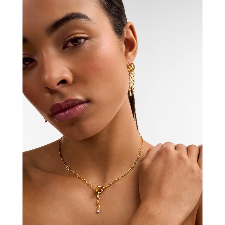 Niche Jewellery Katie Loxton Champagne Hour waterproof gold necklace with a sparkling pendant on a model