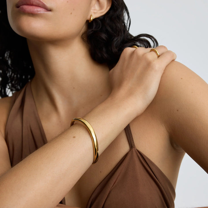 Niche Jewellery gold wave bangle worn by a model, perfect for everyday wear or stacking.