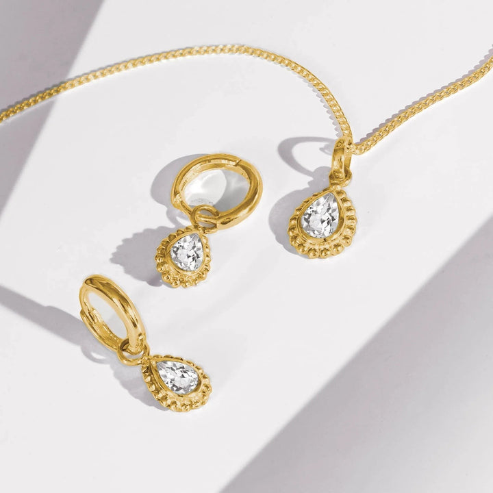 Niche Jewellery Charlotte's Web gold-plated necklace and hoop earrings set featuring pear-shaped white topaz gemstones in beaded settings.