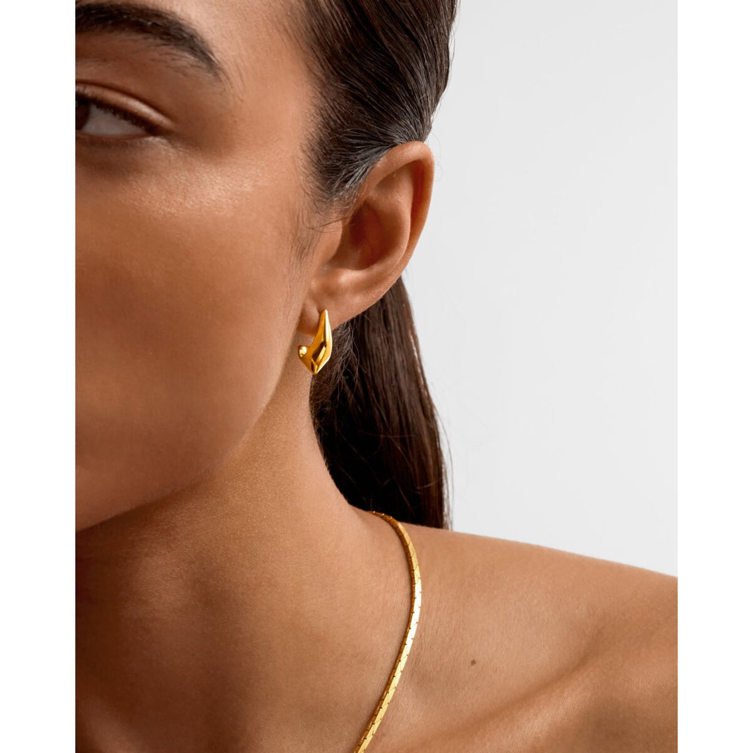 Niche Jewellery Katie Loxton Harlequin waterproof gold hoop earrings with diamond-check detail worn on a model