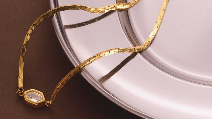 Niche Jewellery Katie Loxton Harlequin waterproof gold-tone necklace with a diamond-check pendant on a flat chain.
