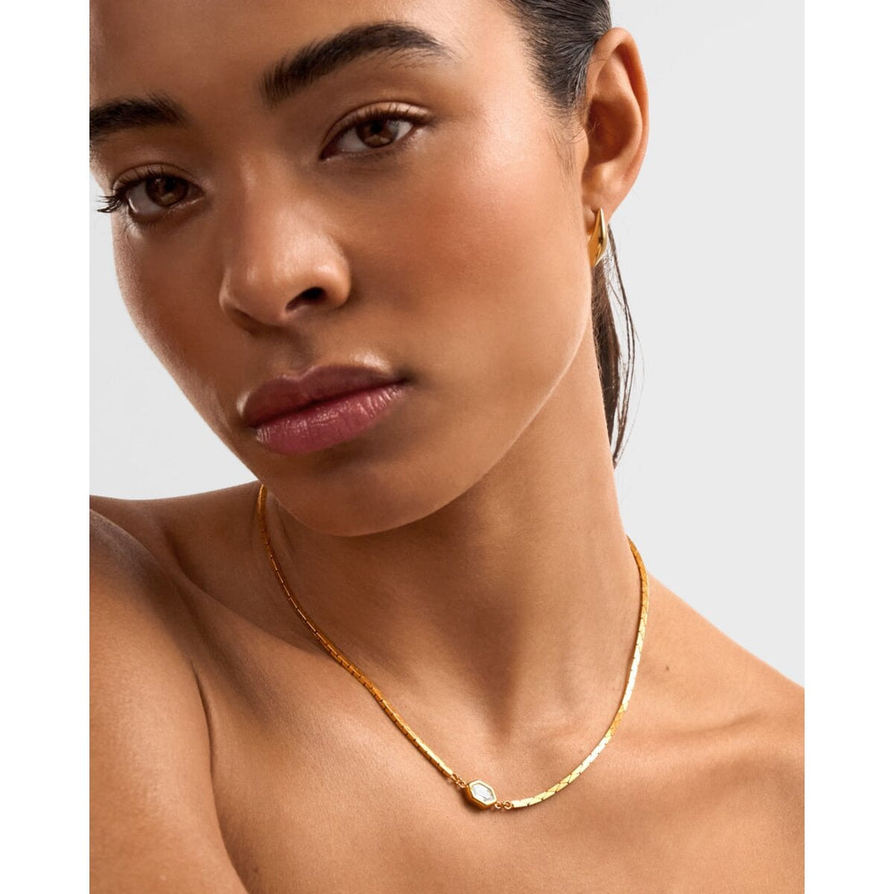 Niche Jewellery Katie Loxton Harlequin waterproof gold-tone necklace with diamond-check pendant on a model