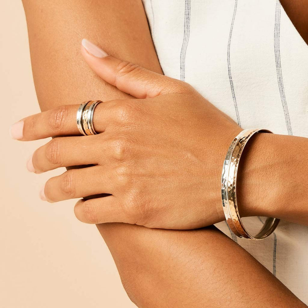 Niche Jewellery Charlotte's Web Karma spinning ring in recycled silver and bronze worn on a woman's finger
