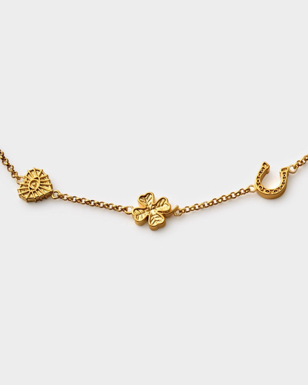 Niche Jewellery Katie Loxton gold-tone waterproof chain bracelet featuring lucky clover, horseshoe, and sun charms.