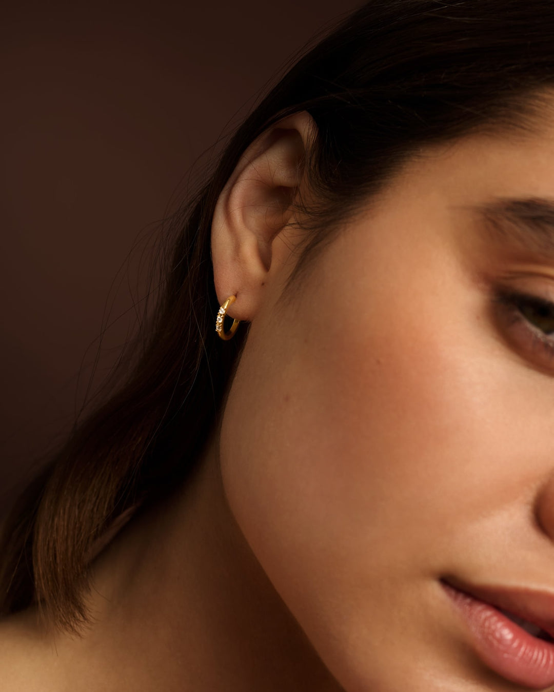 Niche Jewellery Katie Loxton Lumira waterproof gold hoop earring worn on a model's ear