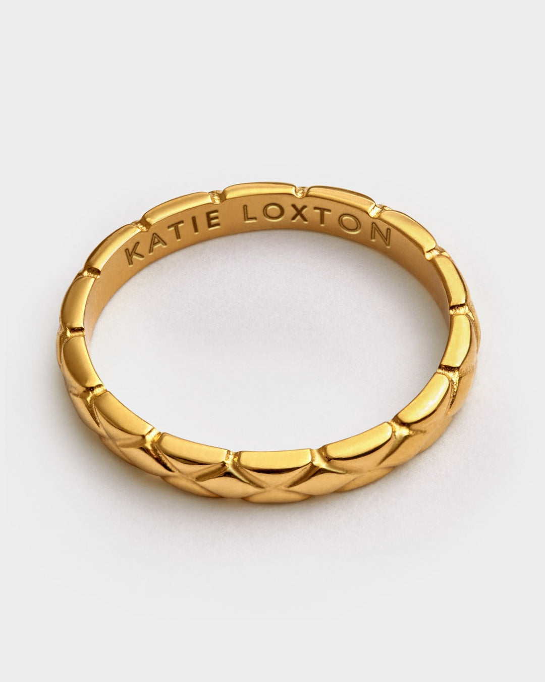 Niche Jewellery Katie Loxton gold-tone waterproof ring featuring a diamond-check pattern and engraved inner band.