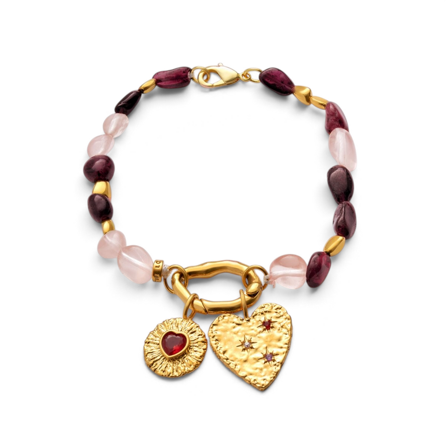 Niche Jewellery Katie Loxton gold-tone bracelet with pink stones, heart charm, and textured sunburst pendant.