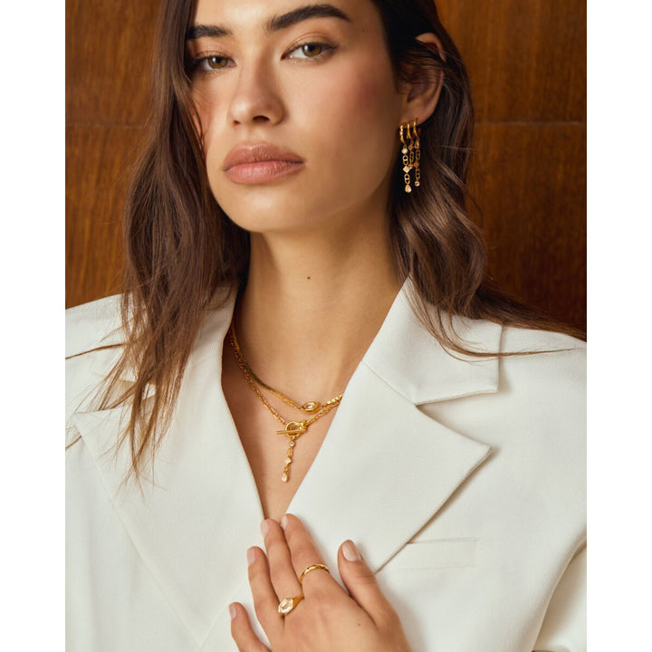 Niche Jewellery Katie Loxton gold waterproof necklace with sparkling pendant worn by a model in a white blazer