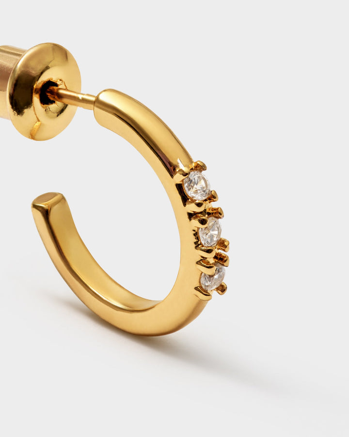 Niche Jewellery Katie Loxton Lumira waterproof gold hoop earrings featuring three small clear stones on a smooth band.