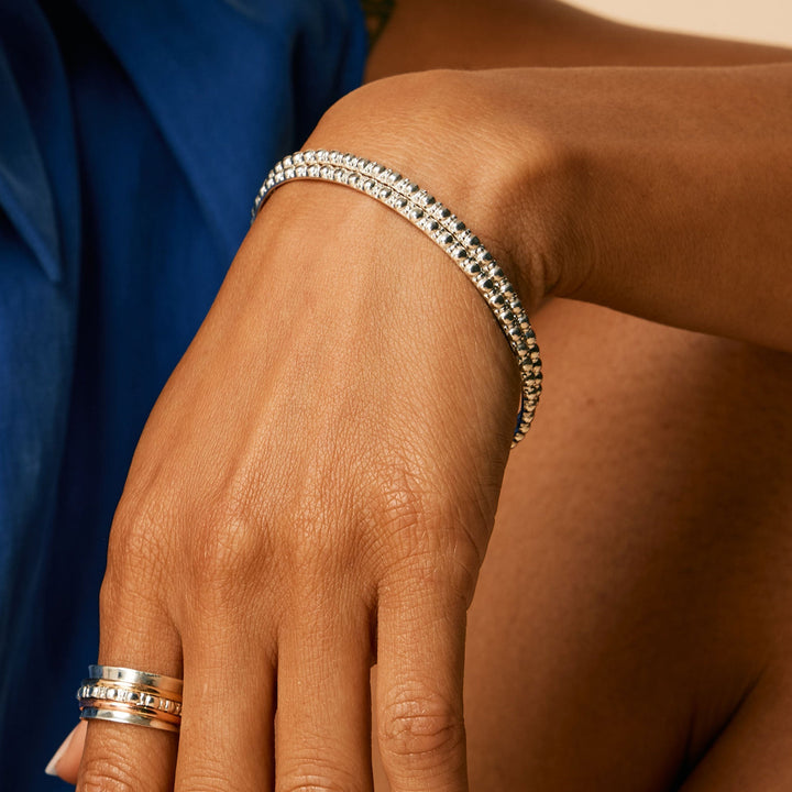 Niche Jewellery Charlotte's Web Maharani sterling silver stacking bangle with signature bubble detailing on a wrist
