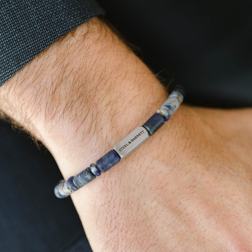 Niche Jewellery Steel & Barnett matte sodalite barrel bead bracelet with a brushed stainless steel logo accent.