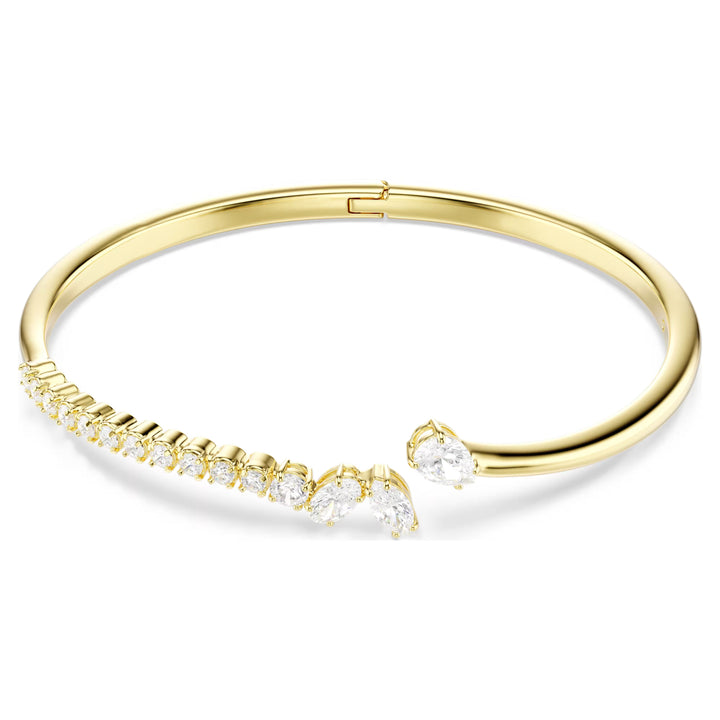 Niche Jewellery Swarovski Mesmera bangle featuring mixed cut white zirconia stones on an 18k gold plated band.