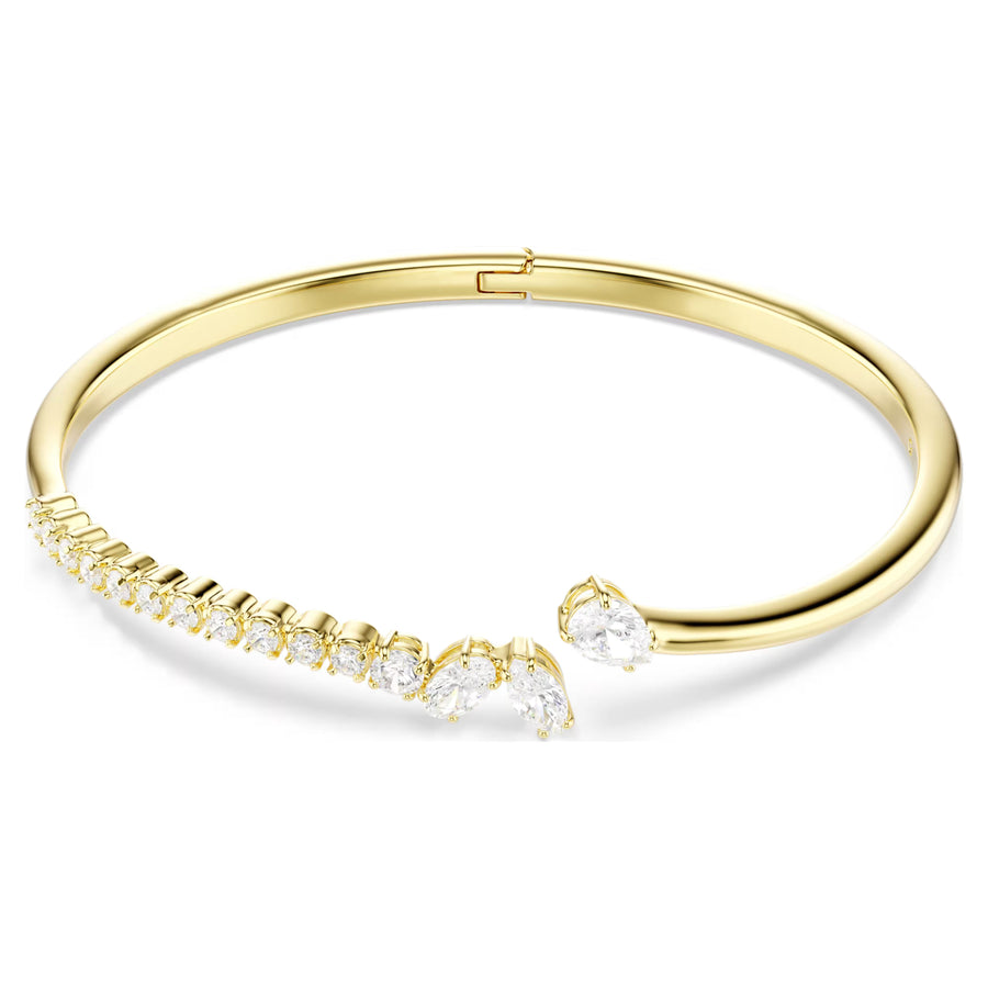 Niche Jewellery Swarovski Mesmera bangle featuring mixed cut white zirconia stones on an 18k gold plated band.