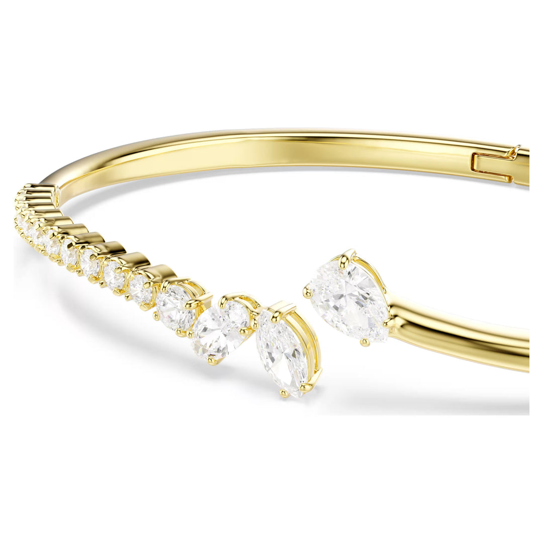 Niche Jewellery Swarovski Mesmera bangle featuring mixed cut white zirconia stones set in an 18k gold finish band.