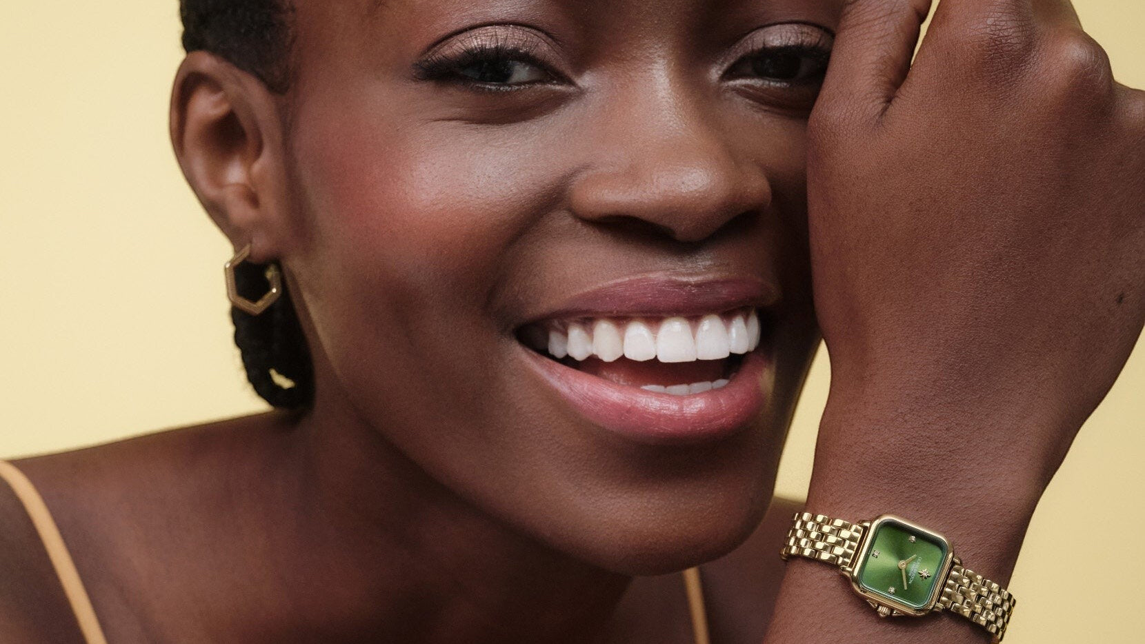 Niche Jewellery Olivia Burton Mini Grosvenor watch with a deep green dial and gold-tone bracelet on a smiling model